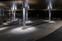 a night view of a parking garage with a staircase and lights on the side walk