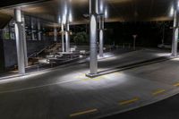 a night view of a parking garage with a staircase and lights on the side walk