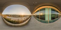 a very close up image of an oval window with buildings behind it at sunset over the mountains