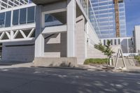 the concrete building is white in color and has windows and stairs leading to it and a construction crane in front