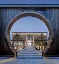 a large entrance and courtyard on the ground of an office building with a round arch