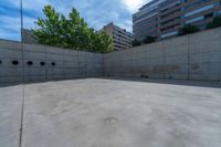 the empty parking lot in front of a wall with apartment buildings on it and a skateboarder on a ramp