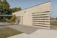 concrete architecture with glass panels along one side and grass, trees on the other side