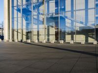 a very tall building with a huge glass facade next to it with a man on his cellphone