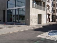 a concrete street corner with parking spaces on both sides of it and a sign on the opposite side