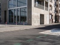 a concrete street corner with parking spaces on both sides of it and a sign on the opposite side