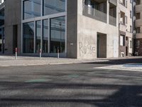 a concrete street corner with parking spaces on both sides of it and a sign on the opposite side