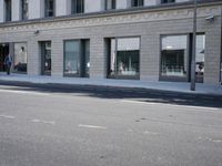 there is a empty street in front of buildings with signs and banners written on the side