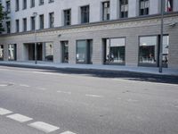 there is a empty street in front of buildings with signs and banners written on the side