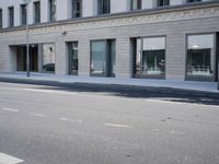 there is a empty street in front of buildings with signs and banners written on the side