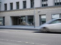 there is a empty street in front of buildings with signs and banners written on the side