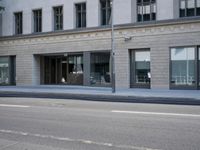 there is a empty street in front of buildings with signs and banners written on the side