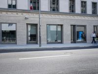 there is a empty street in front of buildings with signs and banners written on the side