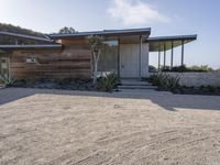 the modern looking house is located in the desert near the ocean and looks like an art deco home