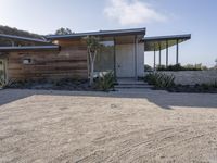 the modern looking house is located in the desert near the ocean and looks like an art deco home