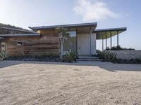 the modern looking house is located in the desert near the ocean and looks like an art deco home