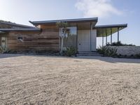 the modern looking house is located in the desert near the ocean and looks like an art deco home