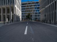 the empty street with bicycles parked in front of the buildings has a sign that says the library on it