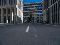 the empty street with bicycles parked in front of the buildings has a sign that says the library on it