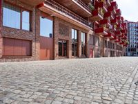 a building with a lot of windows sitting outside of it's door way is brick road