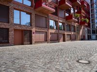 a building with a lot of windows sitting outside of it's door way is brick road
