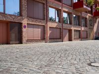 a building with a lot of windows sitting outside of it's door way is brick road