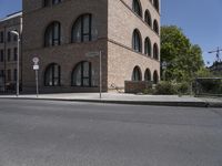 a street corner that is in front of a brick building with large round windows and a circular building top