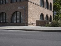 a street corner that is in front of a brick building with large round windows and a circular building top