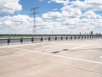 a photo of a runway and sky and road near by a large highway with wires in front