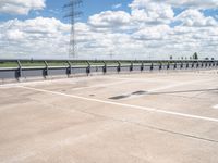 a photo of a runway and sky and road near by a large highway with wires in front