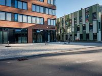 a green and red building surrounded by two rows of brown buildings with blue windows sitting on top of each other