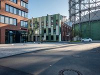 a green and red building surrounded by two rows of brown buildings with blue windows sitting on top of each other
