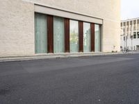 two doors sitting on the side of a building in front of some windows in a room