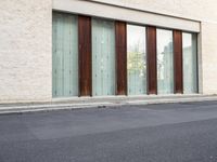 two doors sitting on the side of a building in front of some windows in a room