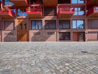 an open courtyard area with red metal buildings in the background with blue skies and blue sky