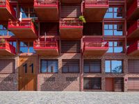 an open courtyard area with red metal buildings in the background with blue skies and blue sky