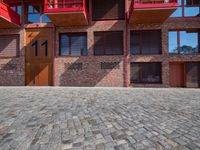 an open courtyard area with red metal buildings in the background with blue skies and blue sky