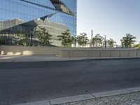 a large building sitting behind a fence near a street corner on a clear day in the evening