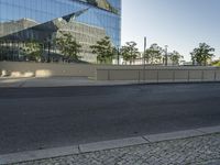 a large building sitting behind a fence near a street corner on a clear day in the evening