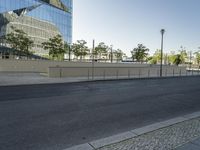 a large building sitting behind a fence near a street corner on a clear day in the evening