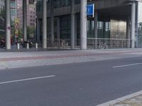 a man on a bike and some buildings and a city street with a bicycle rack