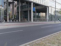 a man on a bike and some buildings and a city street with a bicycle rack