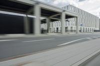 a city highway and the top of a building with columns is shown from a car window