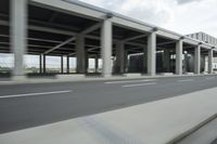 a city highway and the top of a building with columns is shown from a car window