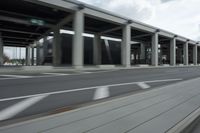 a city highway and the top of a building with columns is shown from a car window