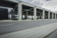 a city highway and the top of a building with columns is shown from a car window