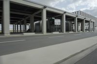 a city highway and the top of a building with columns is shown from a car window