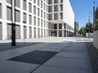 a concrete slab laying in the middle of a sidewalk surrounded by buildings and trees with the light on at the end of the street