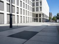 a concrete slab laying in the middle of a sidewalk surrounded by buildings and trees with the light on at the end of the street