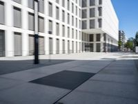 a concrete slab laying in the middle of a sidewalk surrounded by buildings and trees with the light on at the end of the street